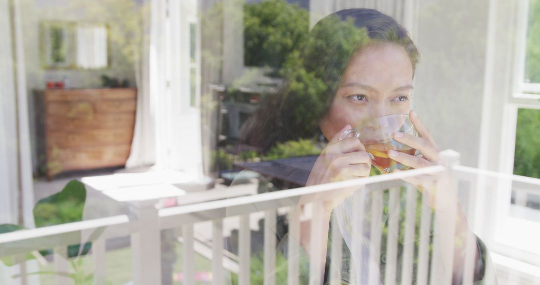 Woman Drinking Tea by Window Reflecting Outdoor Scenery - Free Images, Stock Photos and Pictures on Pikwizard.com