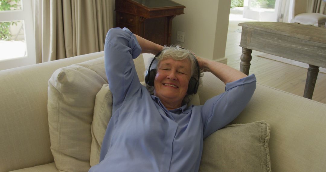 Caucasian senior woman wearing headphones smiling while listening to music at home - Free Images, Stock Photos and Pictures on Pikwizard.com
