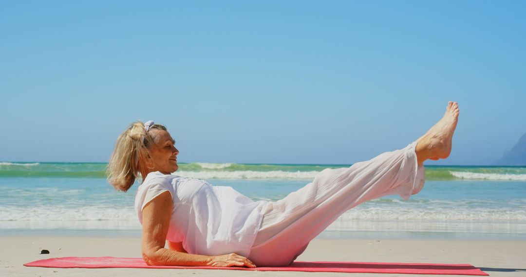Senior Woman Practicing Yoga on Beach with Ocean Background