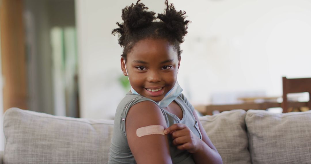 Young Girl Pointing at Bandage on Arm After Vaccination