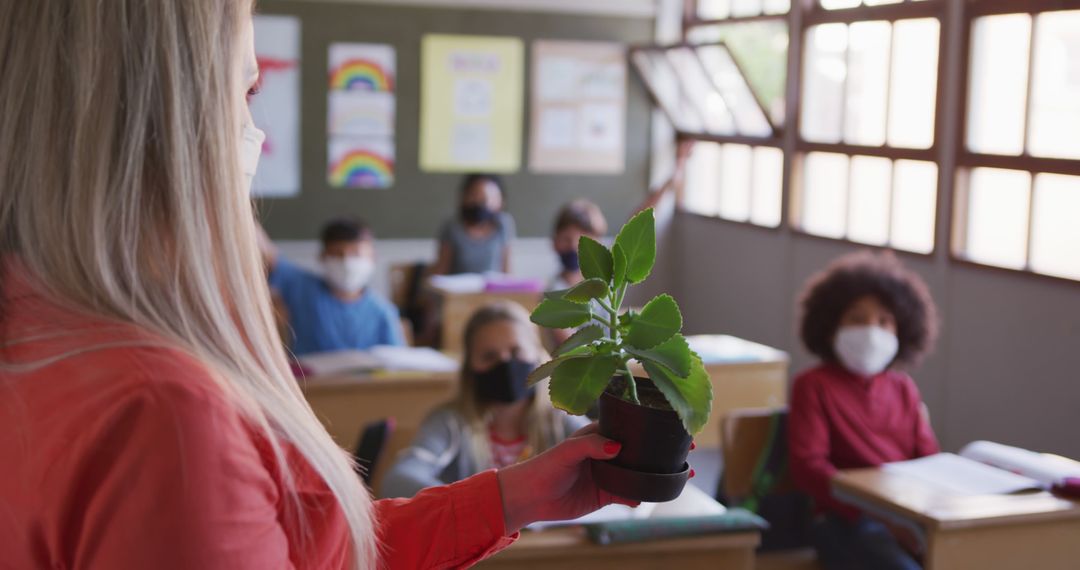 Teacher Showing Potted Plant to Masked Students in Classroom - Free Images, Stock Photos and Pictures on Pikwizard.com