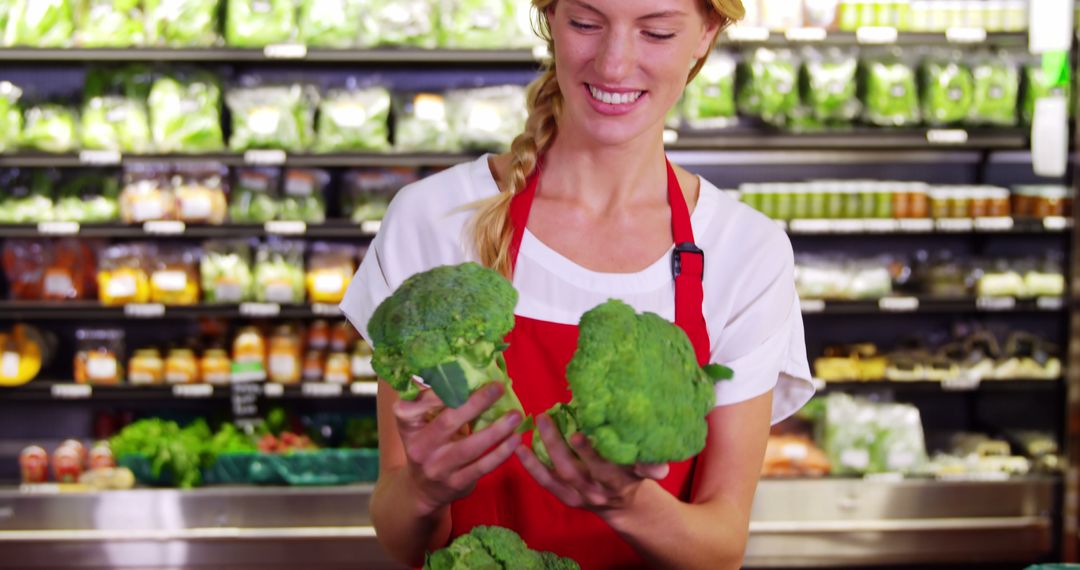 Smiling Female Grocery Worker Sorting Fresh Broccoli in Store - Free Images, Stock Photos and Pictures on Pikwizard.com