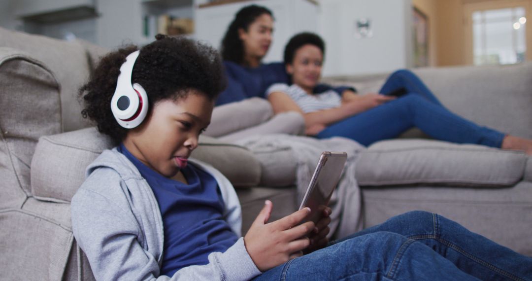 African American Family Lounging, Boy Using Tablet with Headphones - Free Images, Stock Photos and Pictures on Pikwizard.com