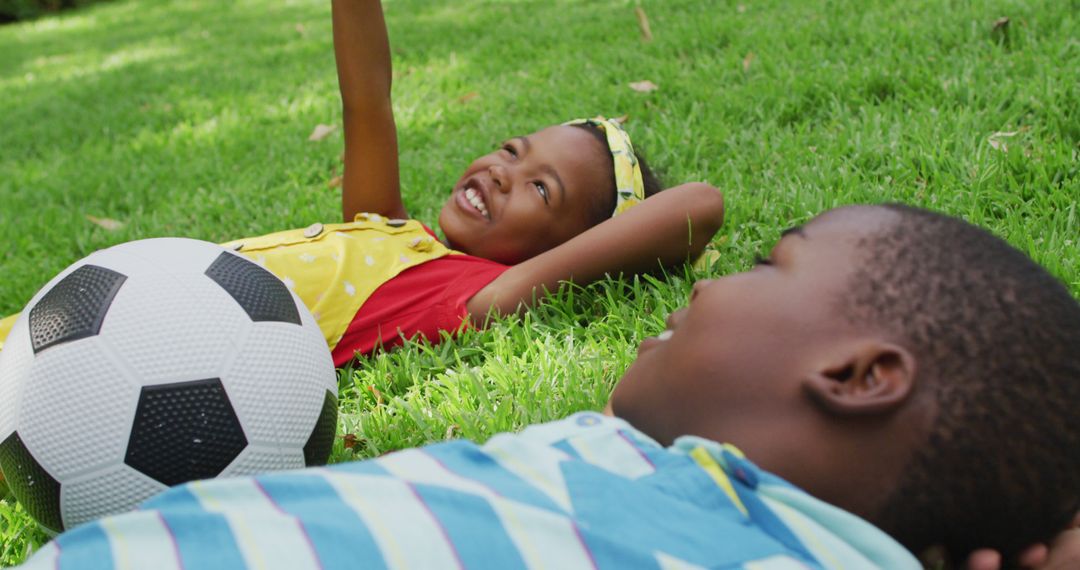 Children Relaxing on Grass with Soccer Ball - Free Images, Stock Photos and Pictures on Pikwizard.com