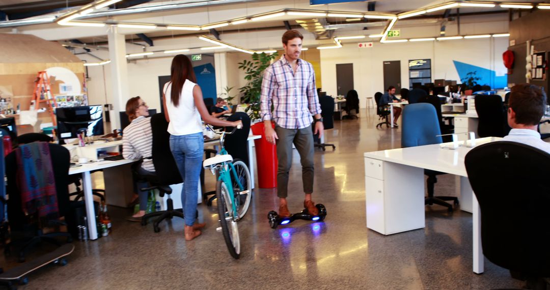 Young Professionals in Modern Office with Hoverboard and Bicycle - Free Images, Stock Photos and Pictures on Pikwizard.com