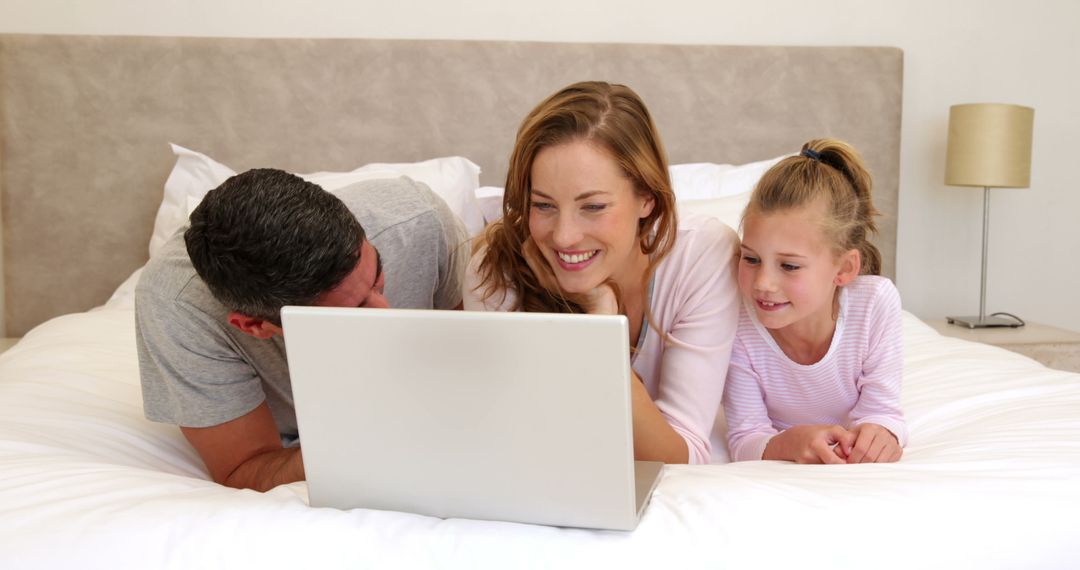 Happy Family Watching Laptop in Bedroom - Free Images, Stock Photos and Pictures on Pikwizard.com