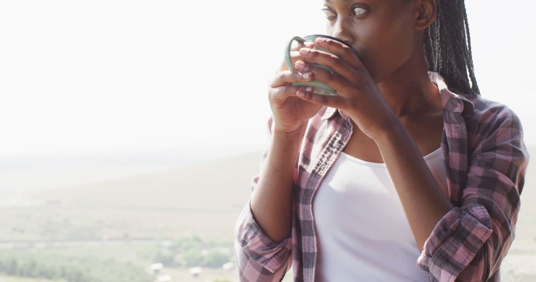 Young Woman Enjoying Coffee Outdoors with Scenic View - Free Images, Stock Photos and Pictures on Pikwizard.com