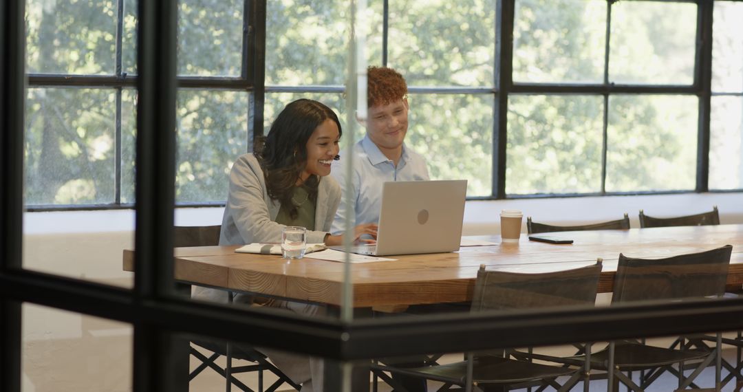 Diverse Colleagues Collaborating at Office Table with Laptop