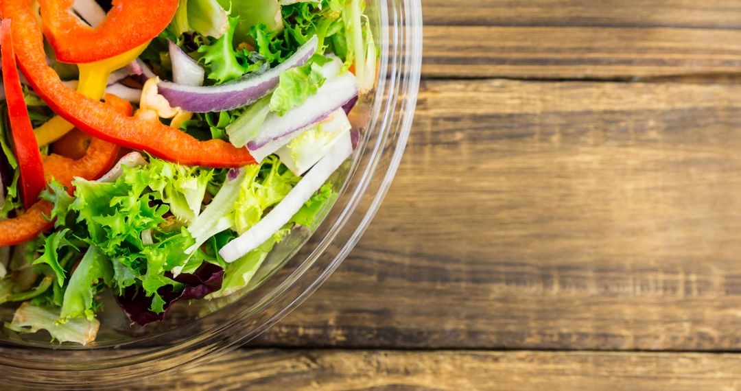 Fresh Mixed Vegetable Salad in Glass Bowl on Rustic Wooden Table