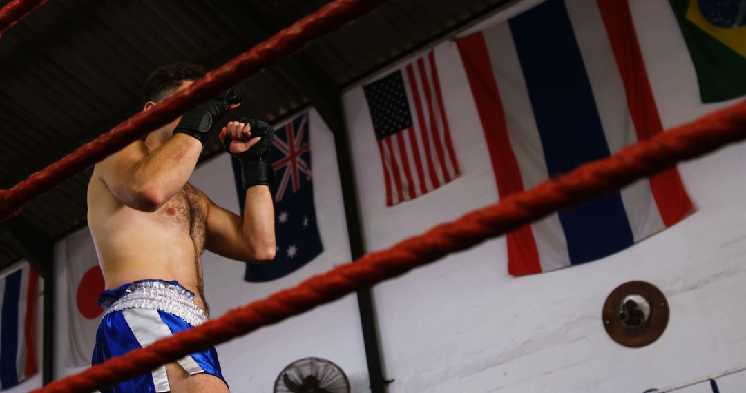 Muay Thai Fighter Sparring in Gym with National Flags in Background - Free Images, Stock Photos and Pictures on Pikwizard.com