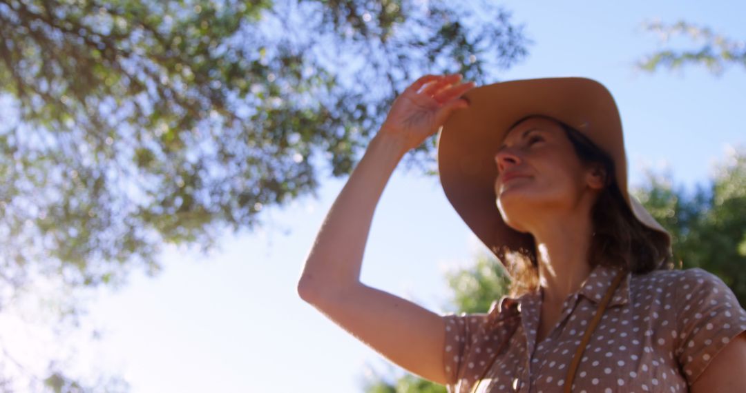 Woman Exploring Outdoors in Wide-Brimmed Hat on Sunny Day - Free Images, Stock Photos and Pictures on Pikwizard.com