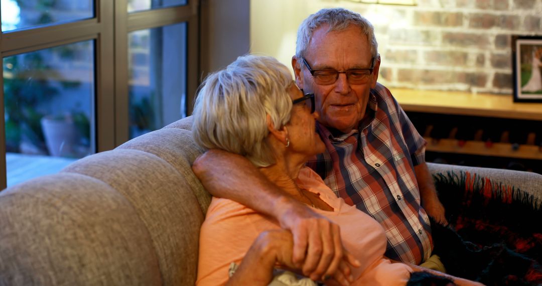 An elderly couple enjoys a cozy, affectionate moment on a couch. - Free Images, Stock Photos and Pictures on Pikwizard.com