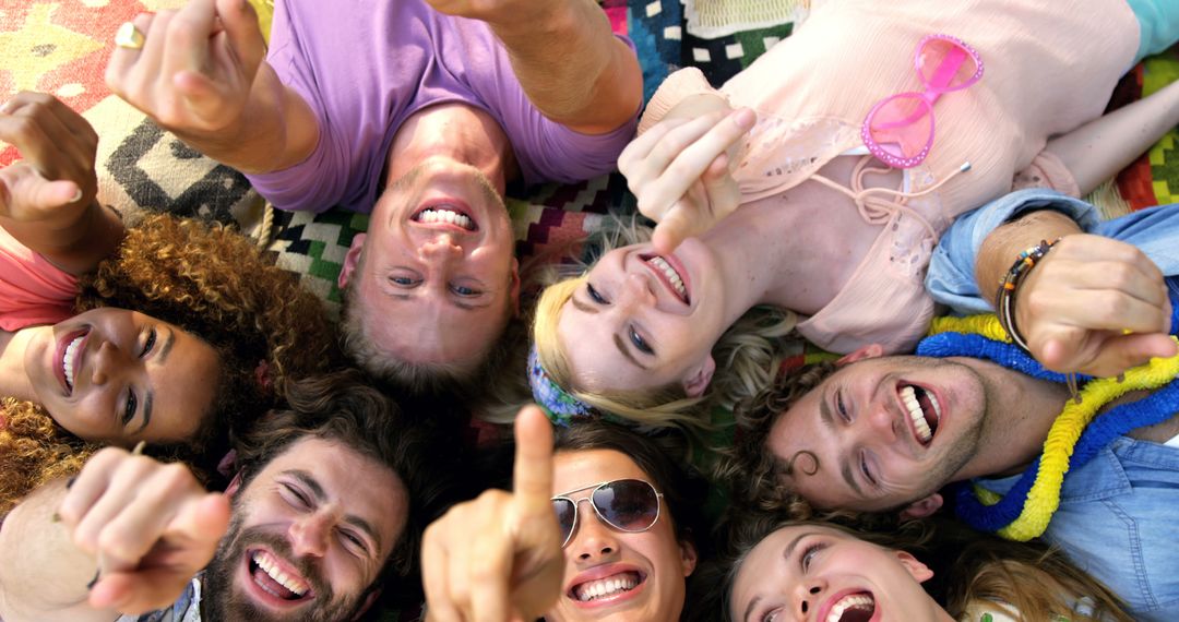 Cheerful Friends Lying On Picnic Blanket, Smiling and Pointing at Camera - Free Images, Stock Photos and Pictures on Pikwizard.com