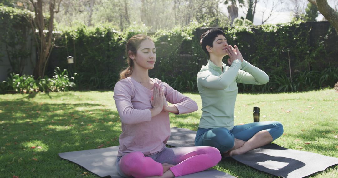 Two Women Practicing Yoga Outdoors in Sunlit Garden - Free Images, Stock Photos and Pictures on Pikwizard.com