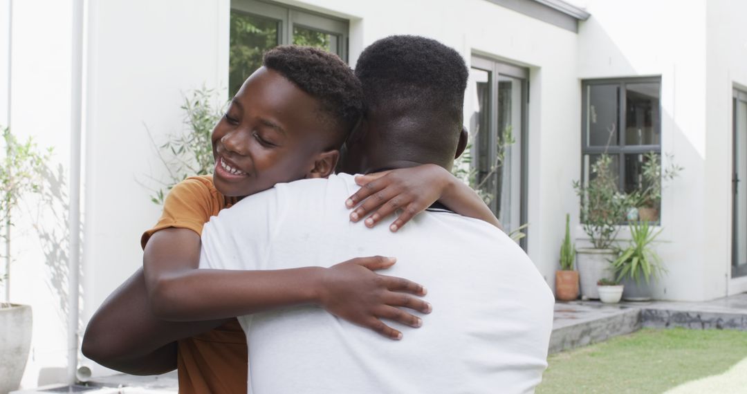 Joyful Father and Son Hugging in Sunlit Garden