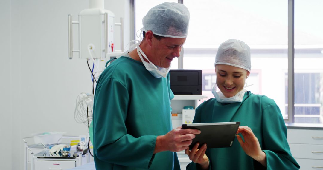 Smiling Surgeons in Operating Room Using Digital Tablet - Free Images, Stock Photos and Pictures on Pikwizard.com