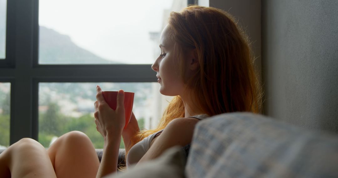 Woman Relaxing at Home with Coffee by Window - Free Images, Stock Photos and Pictures on Pikwizard.com