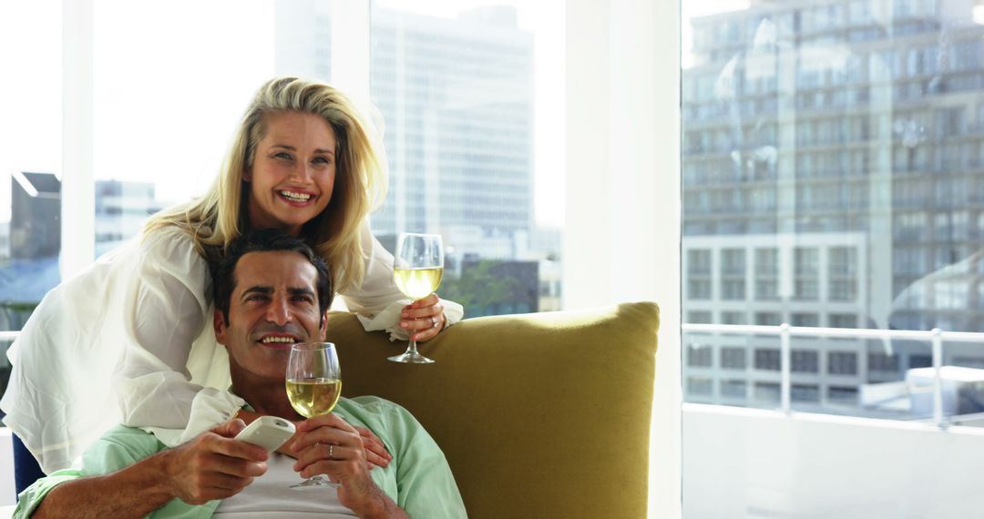 Happy Couple Relaxing Inside Modern Apartment Sharing White Wine - Free Images, Stock Photos and Pictures on Pikwizard.com