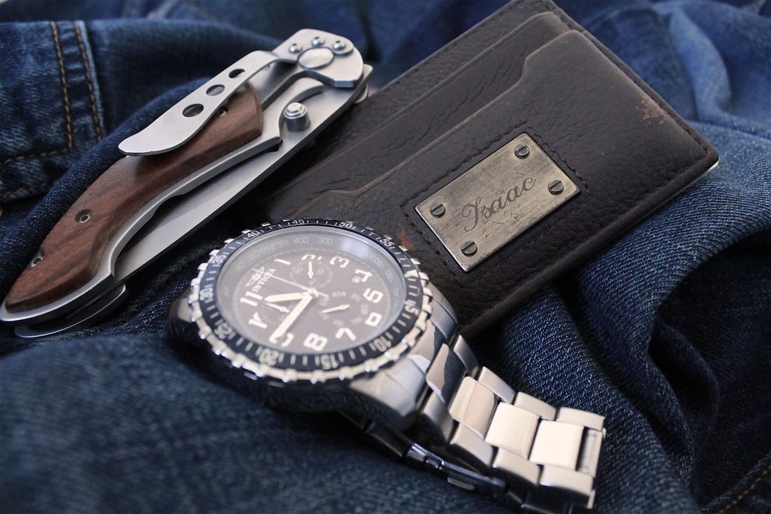 High-End Men's Accessories: Watch, Wallet, and Pocket Knife on Denim Fabric - Free Images, Stock Photos and Pictures on Pikwizard.com