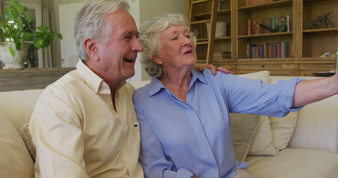 Smiling caucasian senior couple taking a selfie from smartphone sitting on the couch at home - Free Images, Stock Photos and Pictures on Pikwizard.com