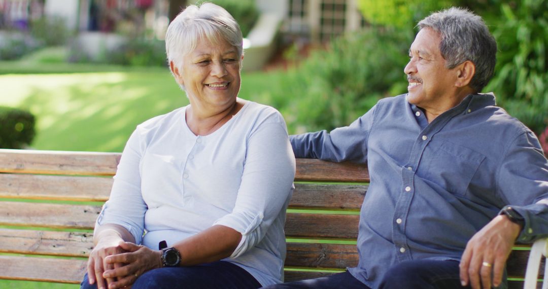 Image of happy biracial senior couple embracing and sitting on bench in garden - Free Images, Stock Photos and Pictures on Pikwizard.com