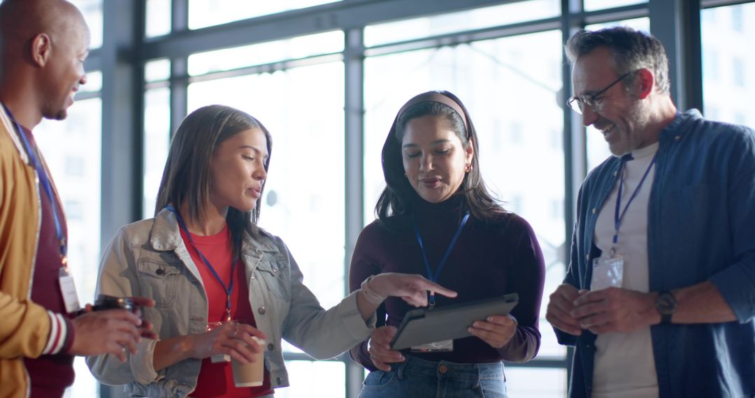 Diverse professionals collaborating around tablet during conference networking in office