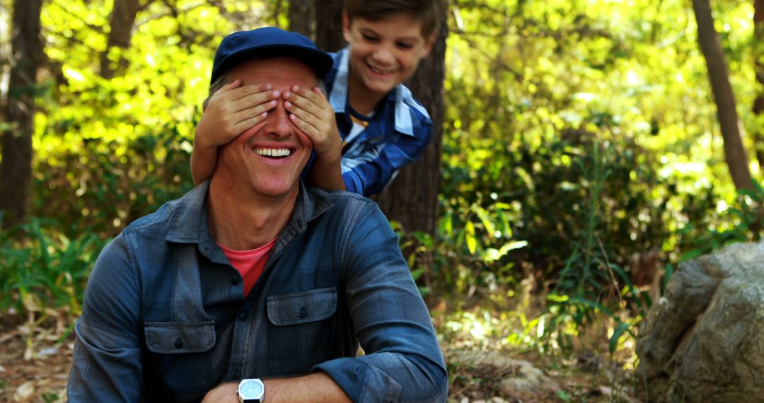 Father and Son Playing Peekaboo Outdoors in Forest - Free Images, Stock Photos and Pictures on Pikwizard.com