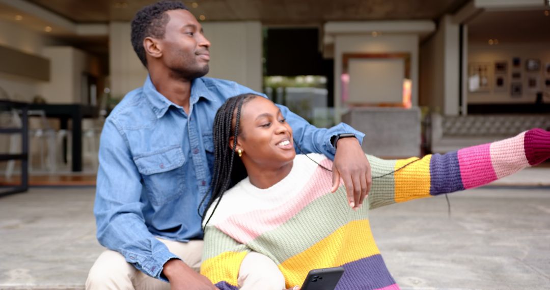 Happy Couple Enjoying Day Out with Smartphone on Building Steps