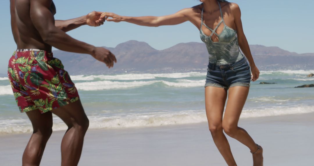 Joyful Couple Dancing on Sandy Beach under Clear Skies - Free Images, Stock Photos and Pictures on Pikwizard.com