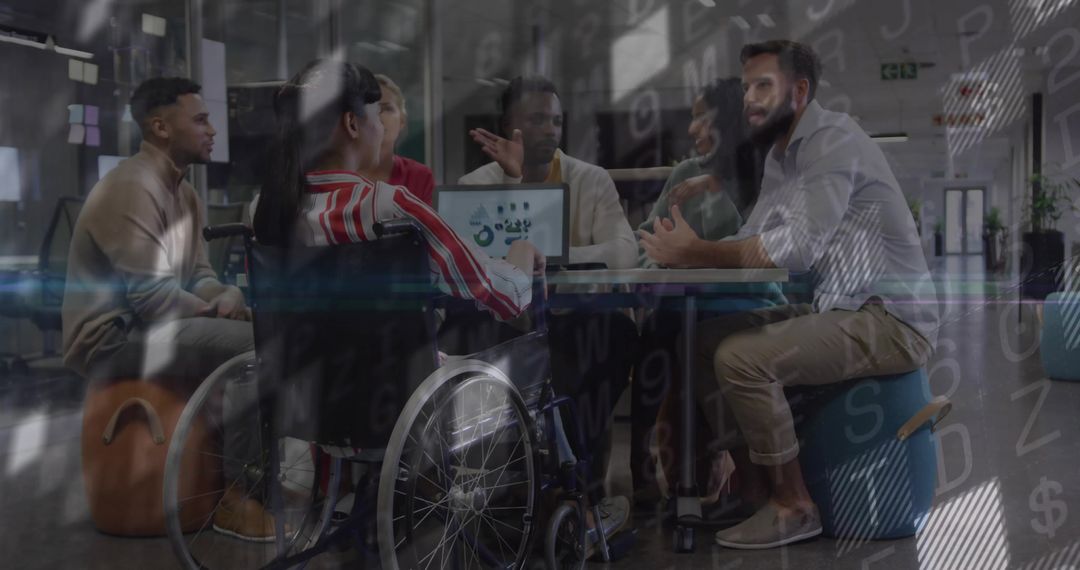 Collaborating team meeting including wheelchair user reviewing data analytics on laptop