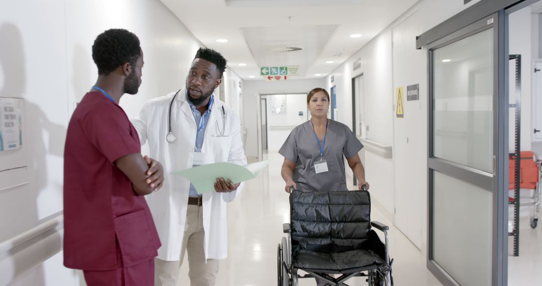 Medical Team Discussing Patient Care in Modern Hospital Corridor - Free Images, Stock Photos and Pictures on Pikwizard.com