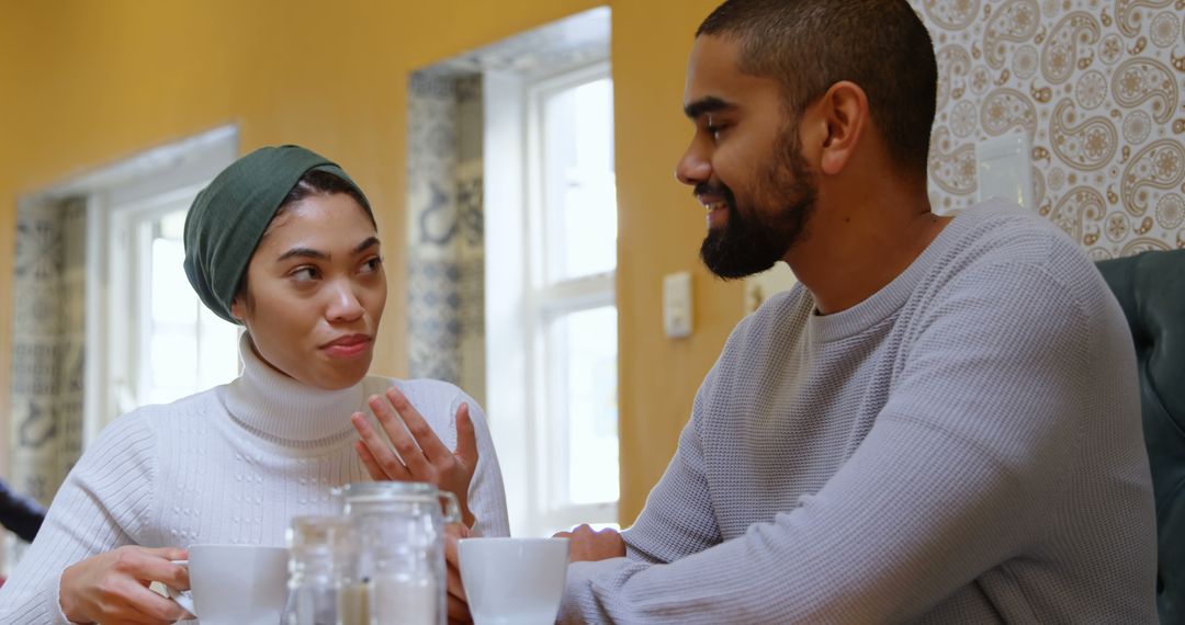 Engaging Couple Conversing Over Breakfast in Cozy Cafe