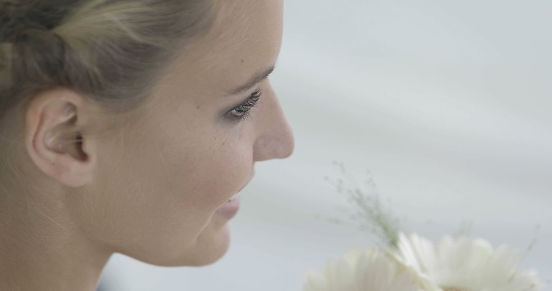 Smiling Woman Holding a White Flower Close-Up Profile - Free Images, Stock Photos and Pictures on Pikwizard.com