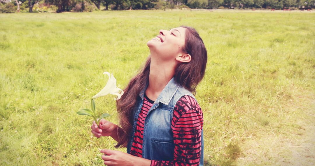 Happy Young Woman Holding Lily in Park Field - Free Images, Stock Photos and Pictures on Pikwizard.com