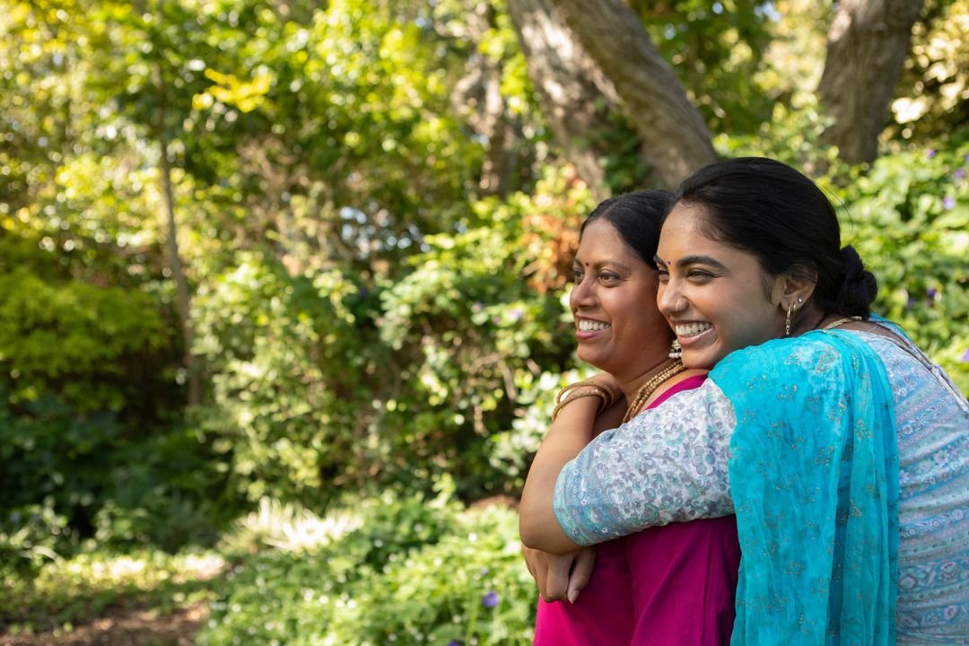 Joyful Mother and Daughter Hugging in Sunlit Garden