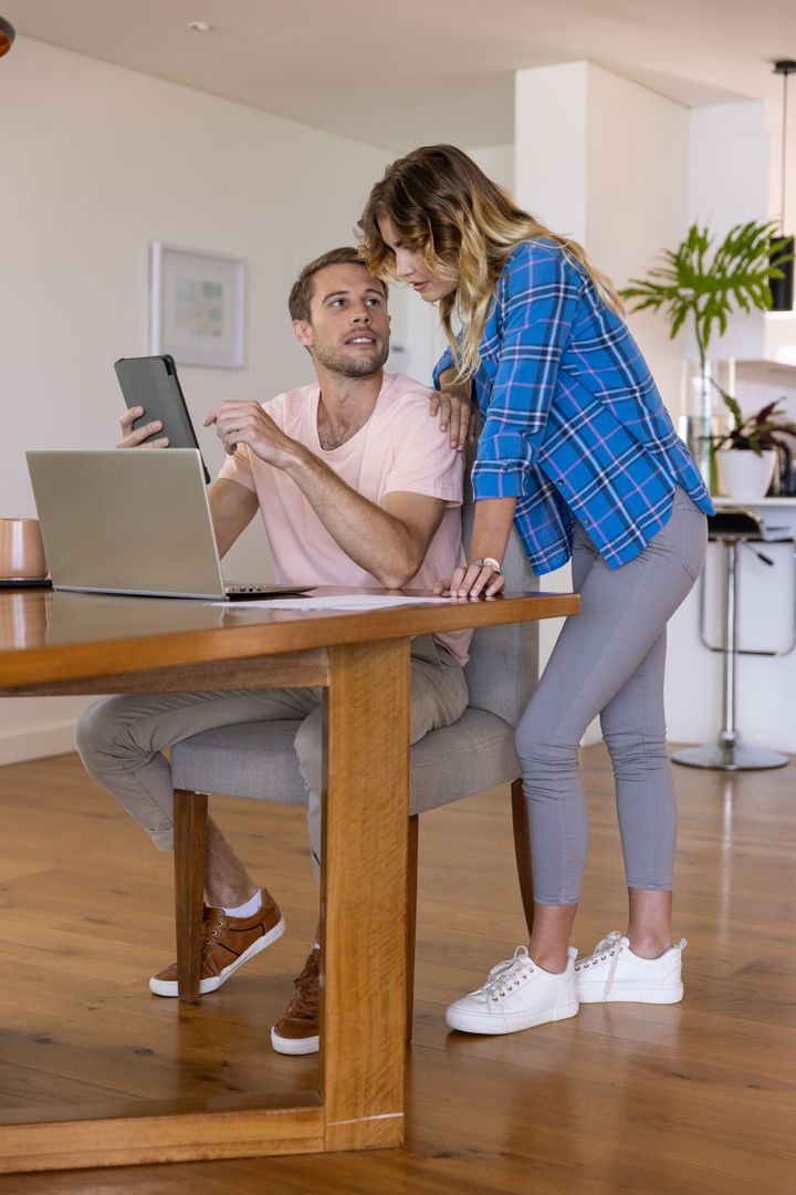 Couple Collaborating Using Digital Devices in Modern Home Office
