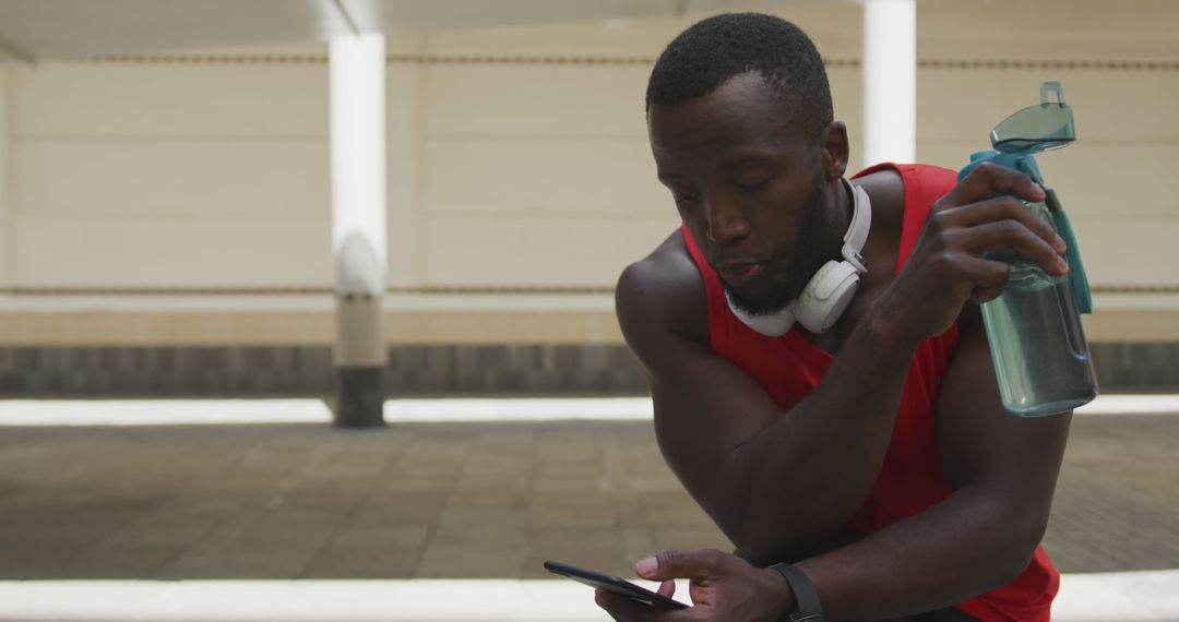 Athletic Man with Headphones Using Smartphone During Workout Break - Free Images, Stock Photos and Pictures on Pikwizard.com