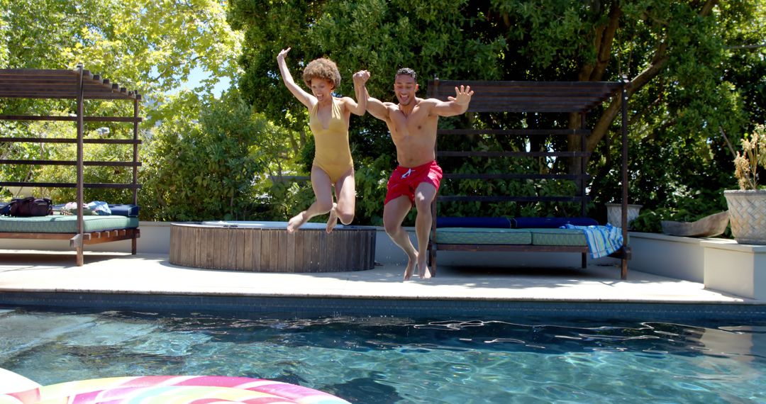 Joyful Friends Jumping into Pool on Sunny Day - Free Images, Stock Photos and Pictures on Pikwizard.com