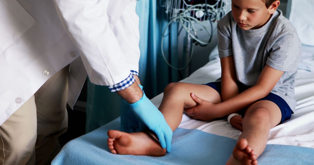 Doctor Examining Young Boy's Leg for Injuries in Hospital Bed - Free Images, Stock Photos and Pictures on Pikwizard.com