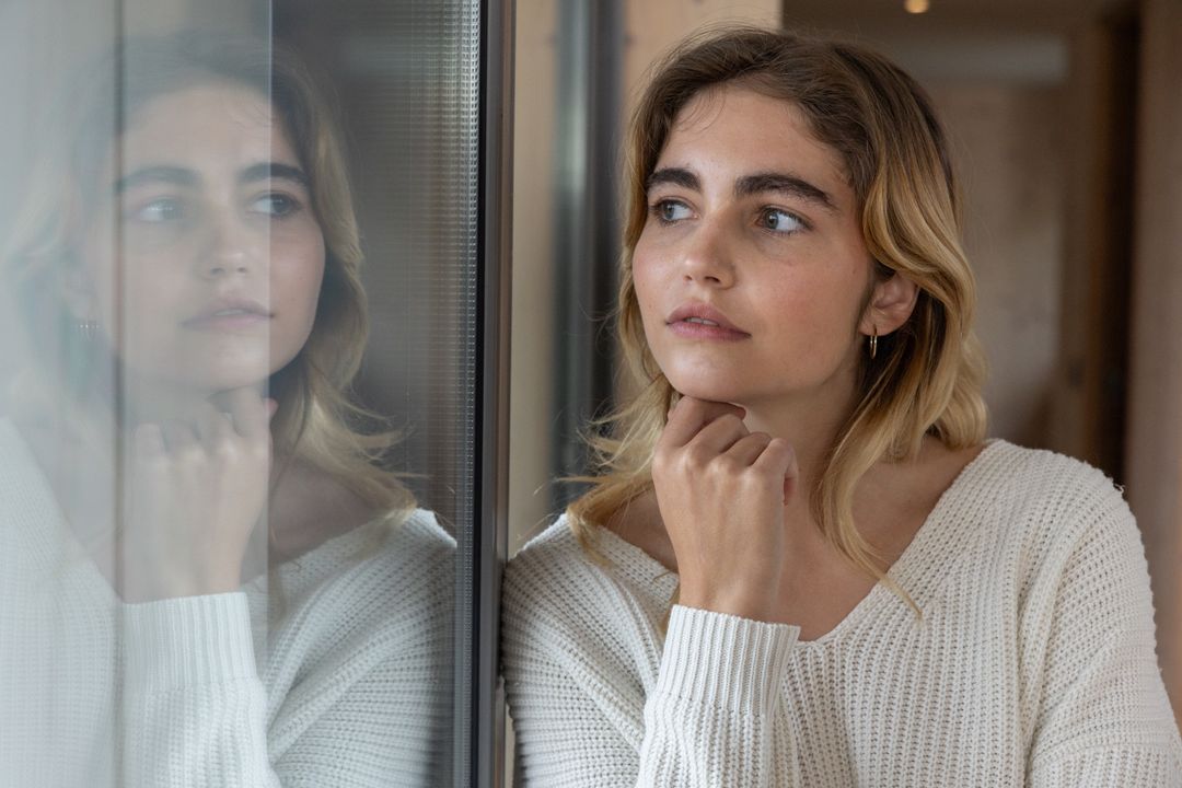 Woman Gazing Reflectively by Window with Contemplative Expression