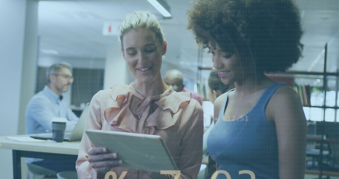 Businesswomen Collaborating with Digital Tablet in Modern Office