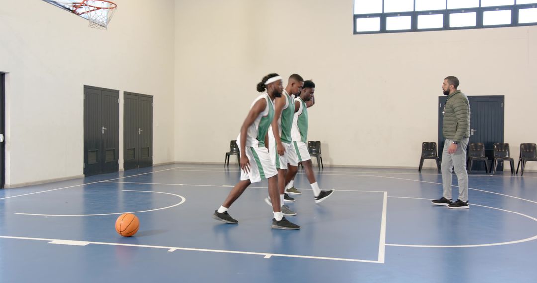Diverse Basketball Team Practicing Footwork in Gym