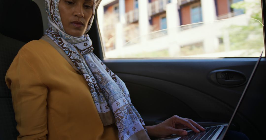 Muslim Woman in Hijab Working on Laptop in Car - Free Images, Stock Photos and Pictures on Pikwizard.com