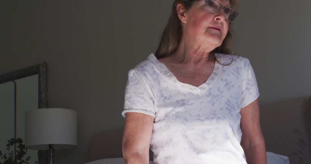 Elderly Woman Sitting on Bed Contemplating - Free Images, Stock Photos and Pictures on Pikwizard.com