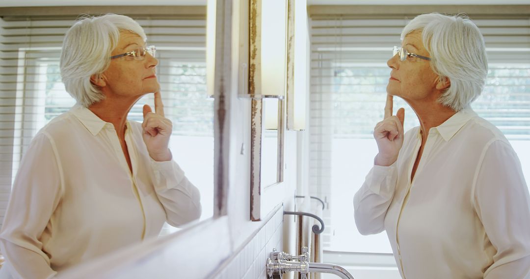 Elderly Woman Inspecting Her Face in Bathroom Mirror - Free Images, Stock Photos and Pictures on Pikwizard.com