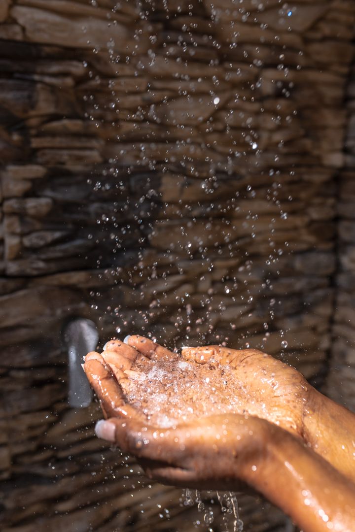 Cropped image of african american young woman's hands cupping falling water in bathroom at home - Free Images, Stock Photos and Pictures on Pikwizard.com