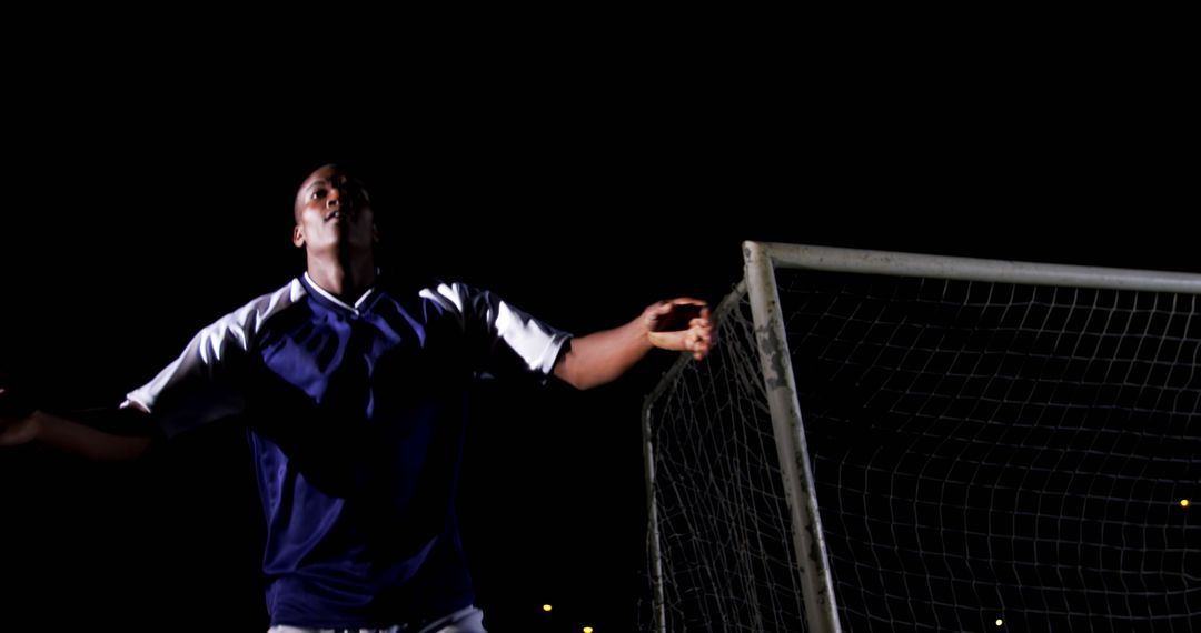 Soccer Player Celebrating After Scoring Goal Under Stadium Lights at Night - Free Images, Stock Photos and Pictures on Pikwizard.com