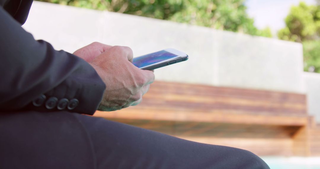 Businessman Using Smartphone Outdoors Near Pool - Free Images, Stock Photos and Pictures on Pikwizard.com