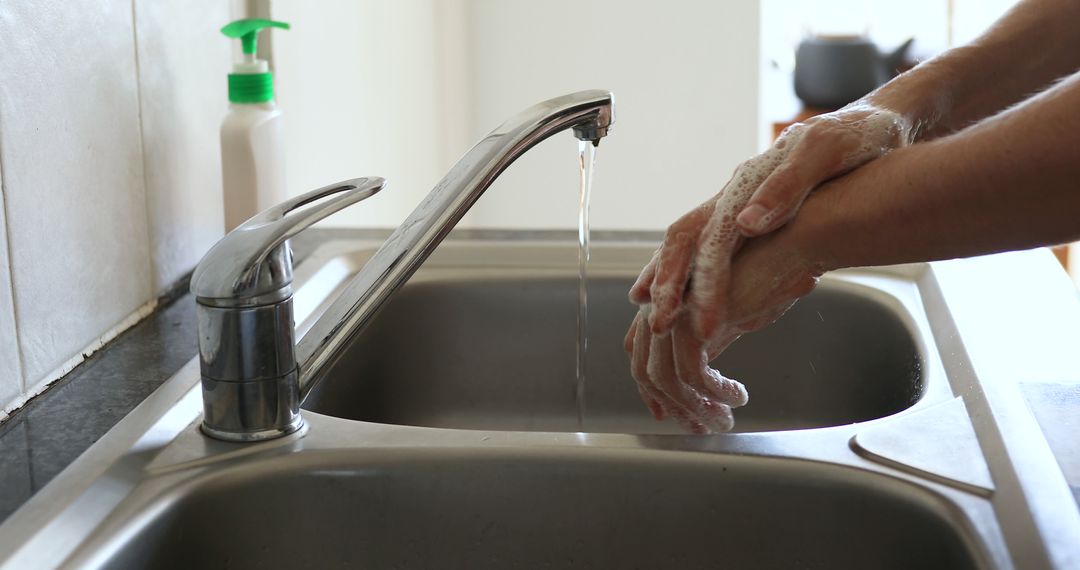 Person Washing Hands Under Running Water in Kitchen Sink - Free Images, Stock Photos and Pictures on Pikwizard.com