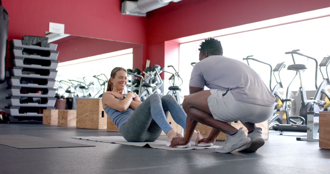 Personal Trainer Assisting Client with Core Workout in Gym